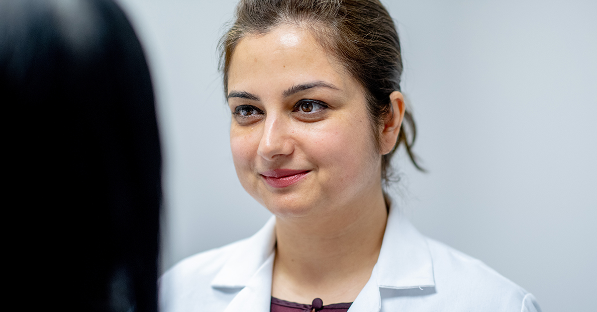 A close up photograph of a medical professional smiling at another person.