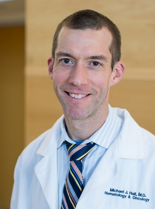 A portrait shot of Michael Hall, MD, MS, smiling at the camera.